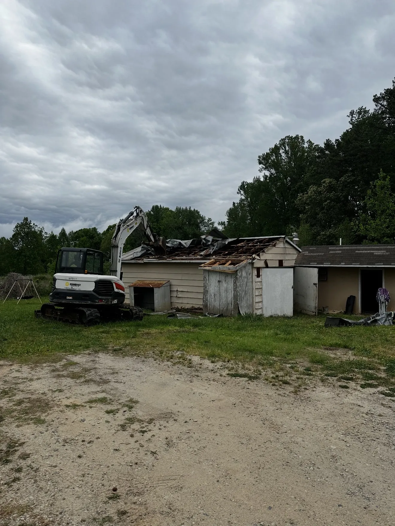 Two sheds and a garage part-way through demolition